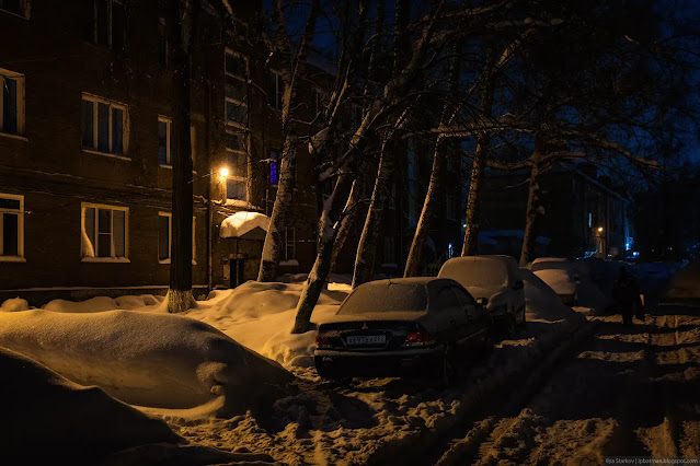Занесенные машины снегом во дворе дома