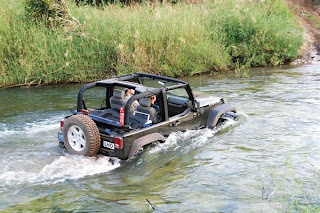 two people in wrangler crossing water