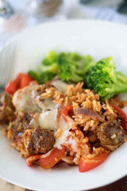 The Easy One Pot Sausage and Rice Bake on a plate with a side of broccoli.
