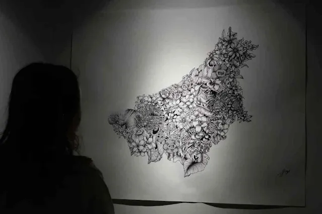 Seorang pengunjung menatap karya lukis di Pameran Art Borneo: Bala Dingan di Gedung Dekranasda Kalbar, Pontianak, Selasa (24/6/2025). © Jessica Wuysang/Antara