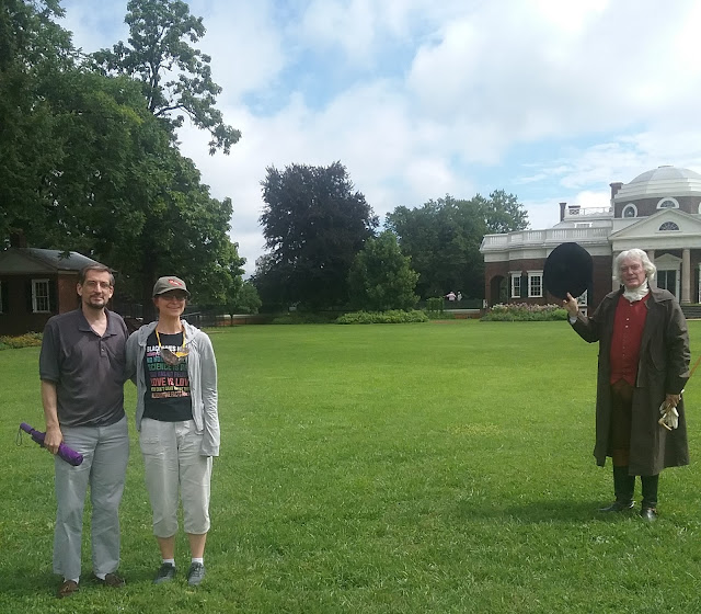 A man and woman stand near an actor dressed as Thomas Jefferson