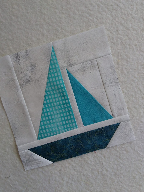 Patchwork quilt block of a sailboat in teal colours