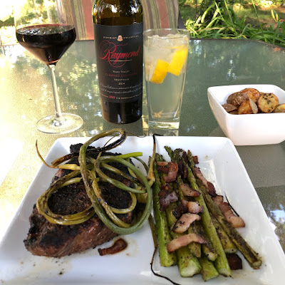 Prime New York Strip with grilled garlic scapes, bacon roasted asparagus, oven roasted mini pototoes with olive oil and fresh thyme