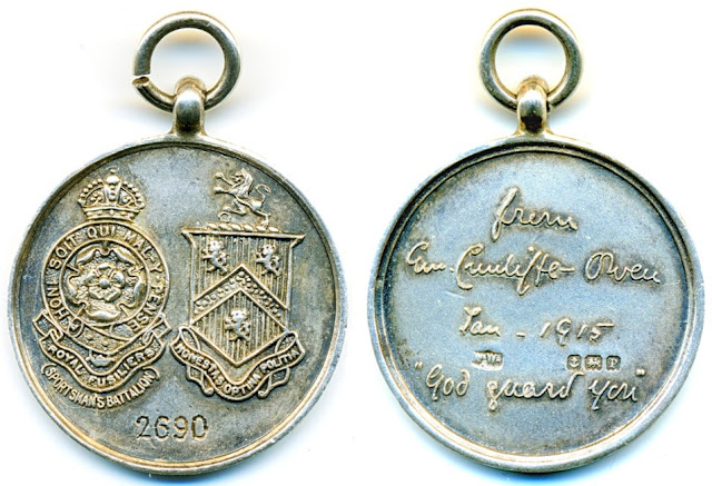 Left - one face of the silver medallion showing a coat of arms and the badge of the Royal Fusilers, the other side showing the dedication from the Cunliffe Owens, and a hallmark