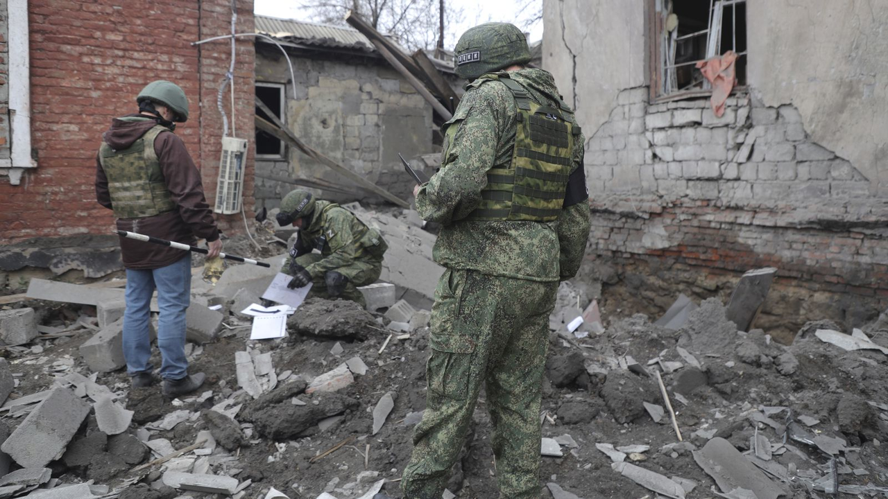 Via AP: Investigators in Makiivka, where the shooting in the video allegedly took place.