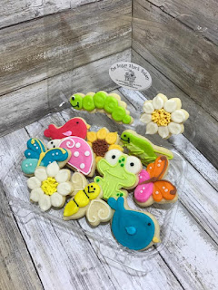 elaborately decorated cookies in spring shapes like birds, butterflies, ladybugs, flowers,frogs, and grasshoppers