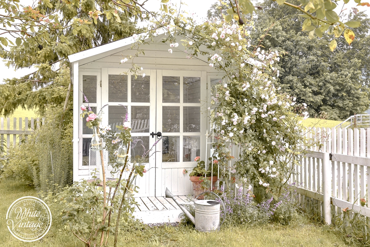 Gartenhaus mit Rosen verwachsen.