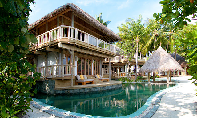 Photo of one of the residences in the resort made of wood with small lake infront of it