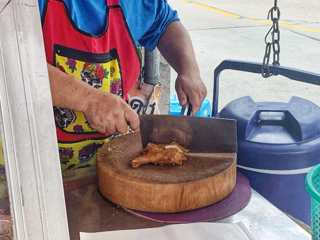 the vendor cuts the Thai street food fried chicken into three pieces