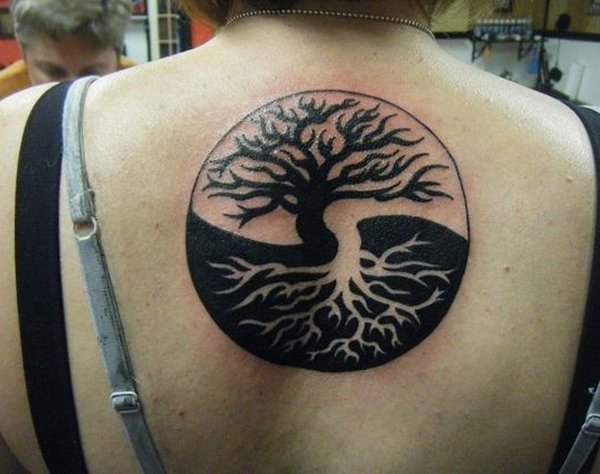 Artisticamente retratada Yin Yang tatuagem nas costas. No lado mostra a luz com uma silhueta escura de árvores, enquanto o outro lado mostra um destaque árvore no meio de um ambiente escurecido.