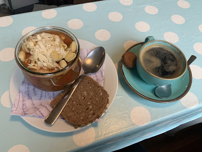 Photo of ratatouille with pasta and bread, next to a coffee