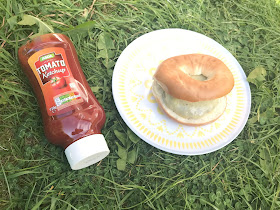 bagel burger on a plate on the grass and asda ketchup bottle 