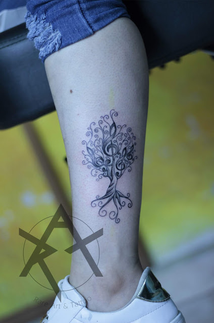 Tatuaje de árbol con notas musicales black and grey