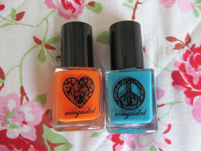 orange and aqua nail polishes. Orange has black heart on bottle, aqua has black peace sign