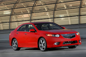 Front three-quarters view of red 2012 Acura TSX on rooftop garage in front of skylight