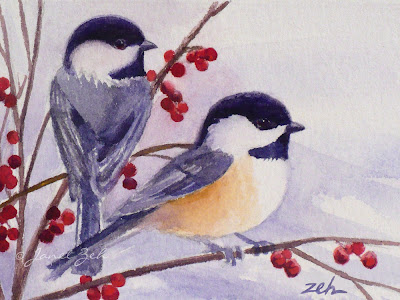 Two chickadees sit in a berry bush in winter