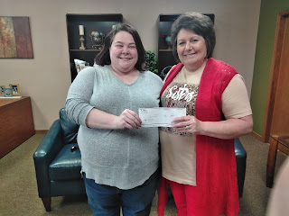 Kimberly Hulit, NTHS President and business student, presents Melinda Chisum of Abundant Life Pregnancy Resource Center with a donation from the UACCM chapter.