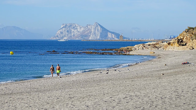 Playa con el agua del mar y el Peñón de Gibraltar al fondo.