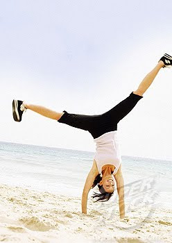 woman making cartwheel at beach