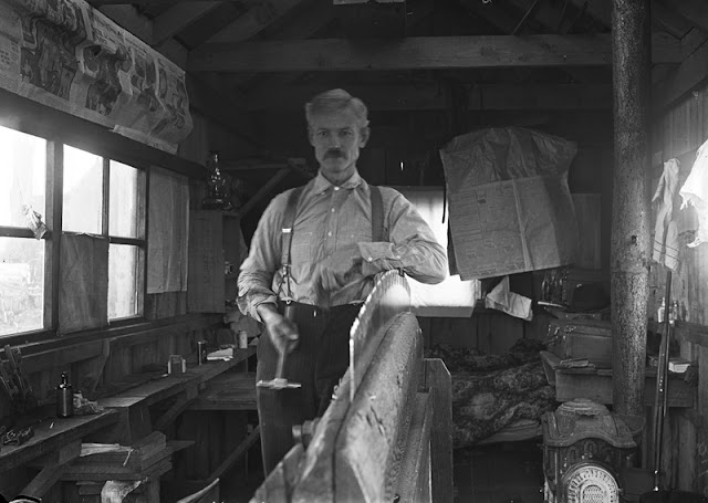 man-with-his-arm-resting-on-a-large-table-saw-blade