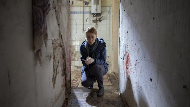 woman crouched at a crime scene