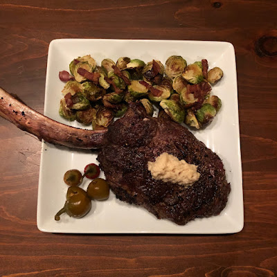 Rare grilled tomahawk ribeye with bacon roasted Brussels sprouts