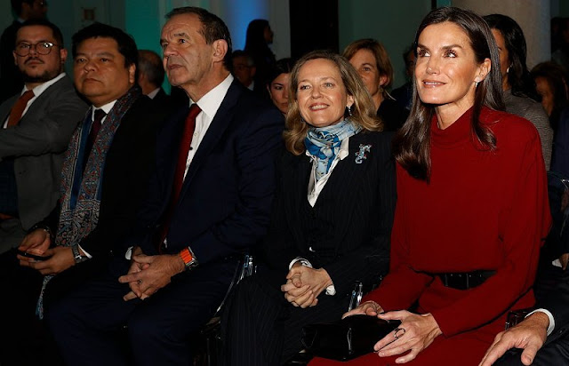 Queen Letizia wore a burgundy, maroon, wine red, high neck open-back dress by Massimo Dutti. Black coat