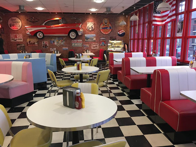 Interior of Hot Rod Diner in Gravesend, Kent, featuring chequerboard floor, American signs on the walls, and leather booth seating.