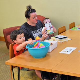 Parent with two children play at table