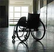 Imagen de una silla de ruedas sin nadie en el ella, en medio de un pasillo solitaria 