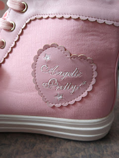 A closeup of the high top shoe showing the angelic pretty logo on a pleather scalloped heart on the heel of the shoe.