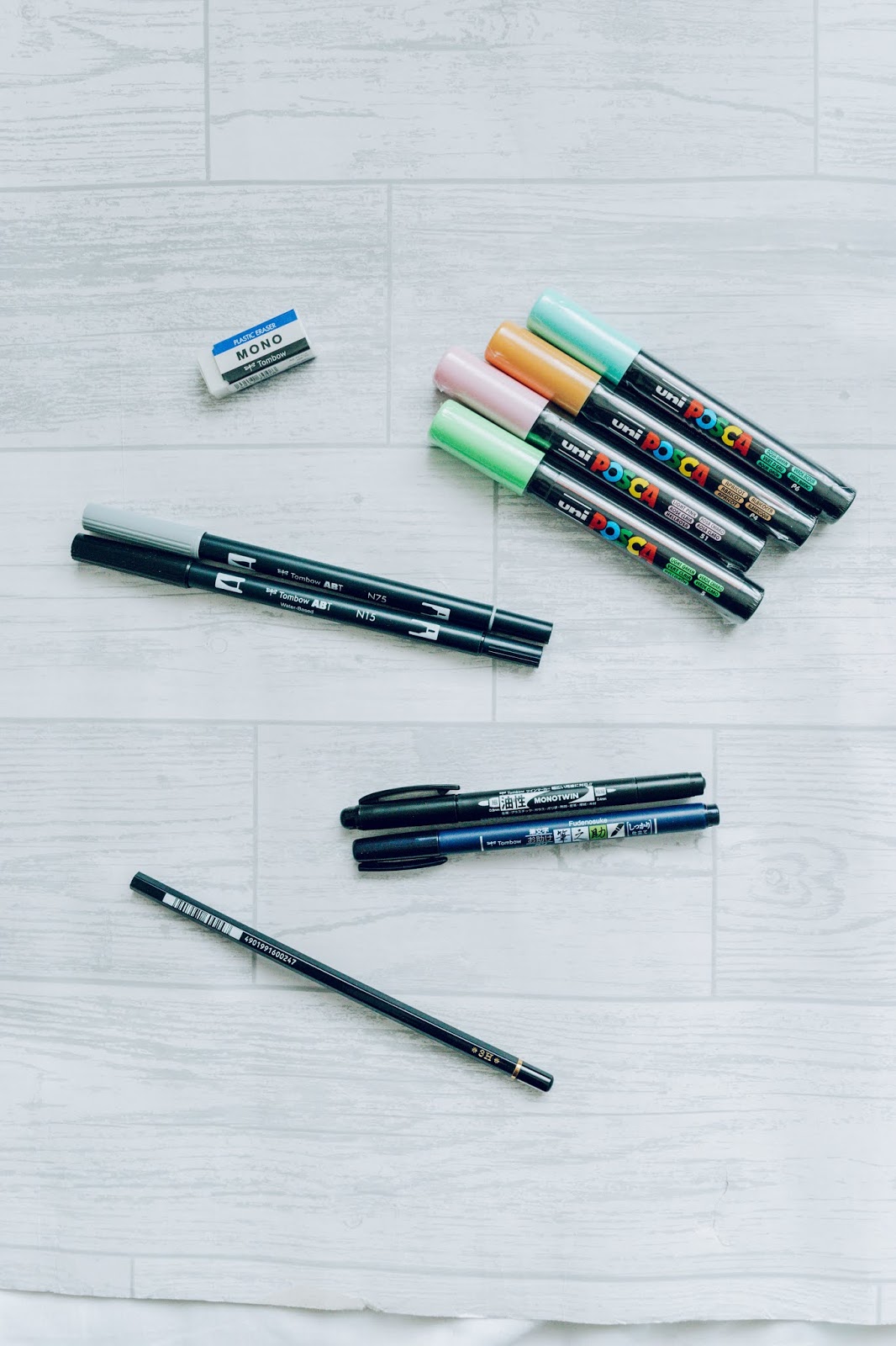 A selection of various colourful and black brush pens and paint pens.