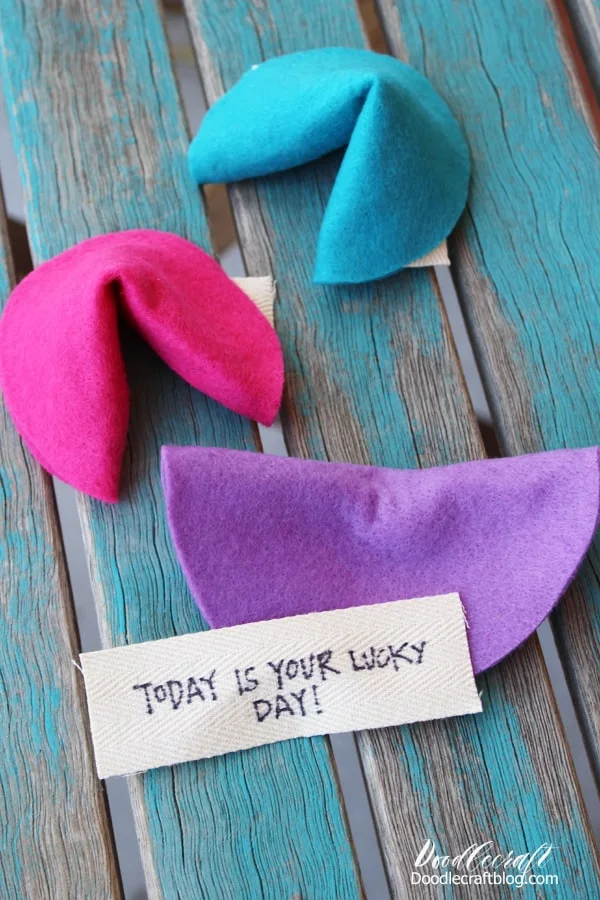 How to Make Felt Fortune Cookies!  I love fortune cookies! I love picking a fortune cookie and hoping for an actual fortune, but alas, a witty quip or odd saying. Make your own cookies and include actual fortunes!    These colorful felt fortune cookies are easy to make and take less than 15 minutes.  They are perfect reusable play food toys.     Make a bunch of brightly colored fortune cookies for imaginative play, as a decoration, or string them up on a garland!