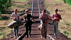 The four boys from Stand By Me. They've all got a backpack or bag, and are walking in a line along the railway tracks.