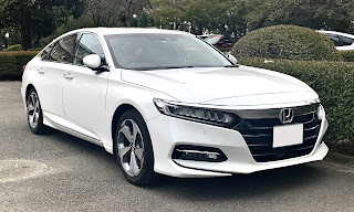 Honda Accord white coloured sort of like sports car look to it in golf course style of carpark for looks