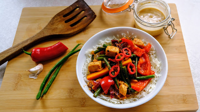 Vegan Gado Gado on a chopping board with chilli, garlic and beans