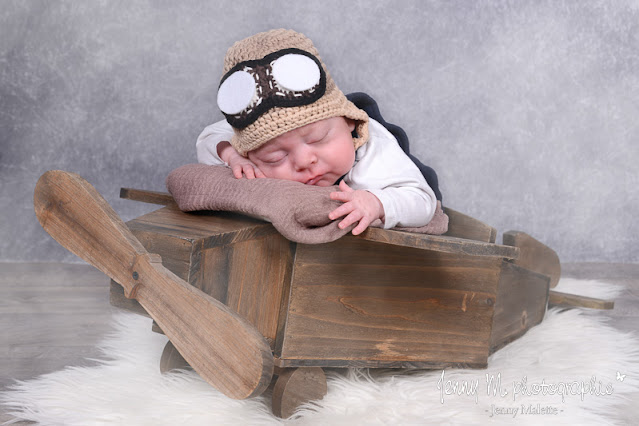 photo bébé sur avion en bois avec bonnet aviateur