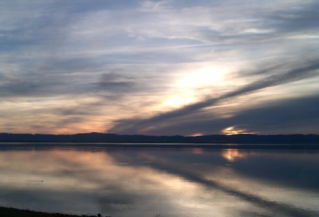 Reflection of clouds and sunset on the water