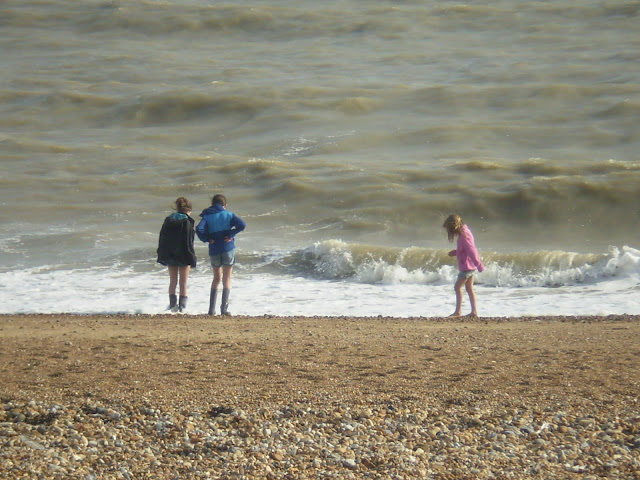 windy beach in summer with children in wellies