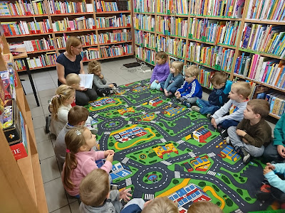 Na zdjęciu bibliotekarz i grupa przedszkolaków