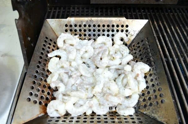 Shrimp in a grill pan on barbecue for Grilled Romaine Salad.