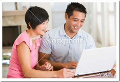 stock-photo-16874907-couple-in-dining-room-with-laptop-smiling