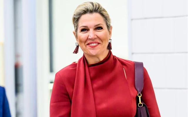 Queen Maxima wore a waxed linen, cactus-leather claret red skirt, and a red scarf blouse by Natan. Edouard Vermeulen