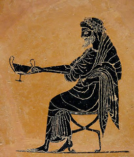 Seated Greek god Dionysos holding out a kantharos  (Greek Cup) and drinking wine.