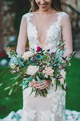 bride carrying asymmetrical bouquet with pink and blue floral