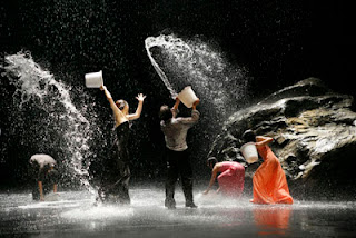 Dancers with buckets of water splashing each other 