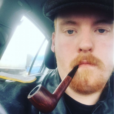 Ginger pilot in mouth wearing black leather jacket with beautiful blue eyes head only