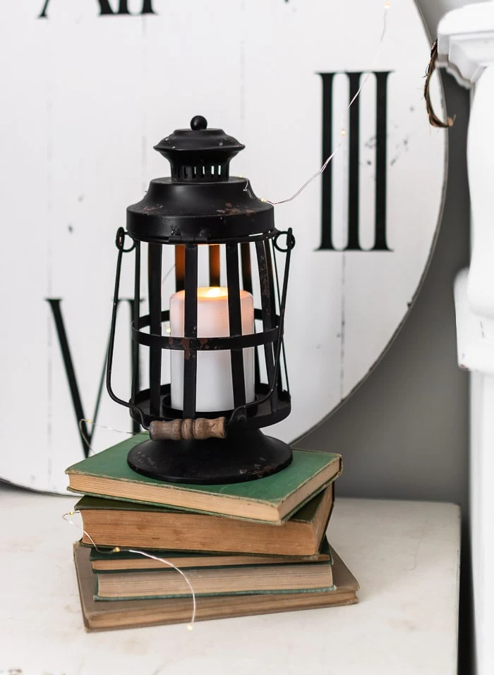 black lantern, candle, vintage book stack