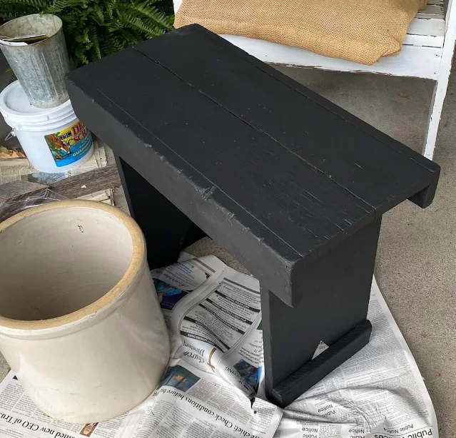 Photo of a wooden bench painted black.