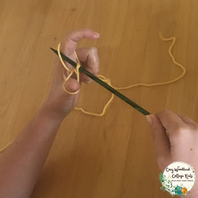 picture of placing the needle through the strand of yarn by your index finger